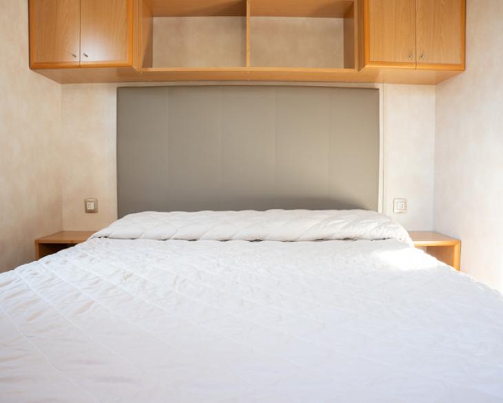 Chambre avec lit double et armoires en bois.