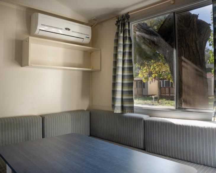 Salle à manger avec canapé, table et climatisation.
