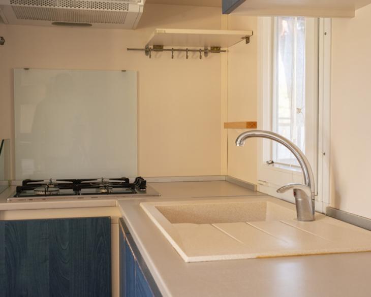 Cuisine moderne avec évier beige et cuisinière à gaz.