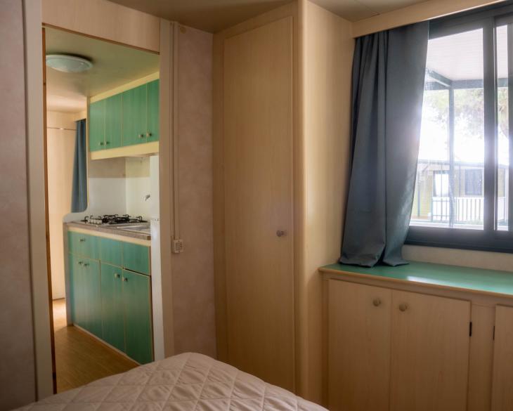 Intérieur de maison mobile avec cuisine et fenêtre.